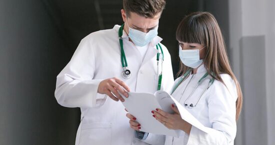 dois médicos reunidos avaliando a gestão de custos com laudos